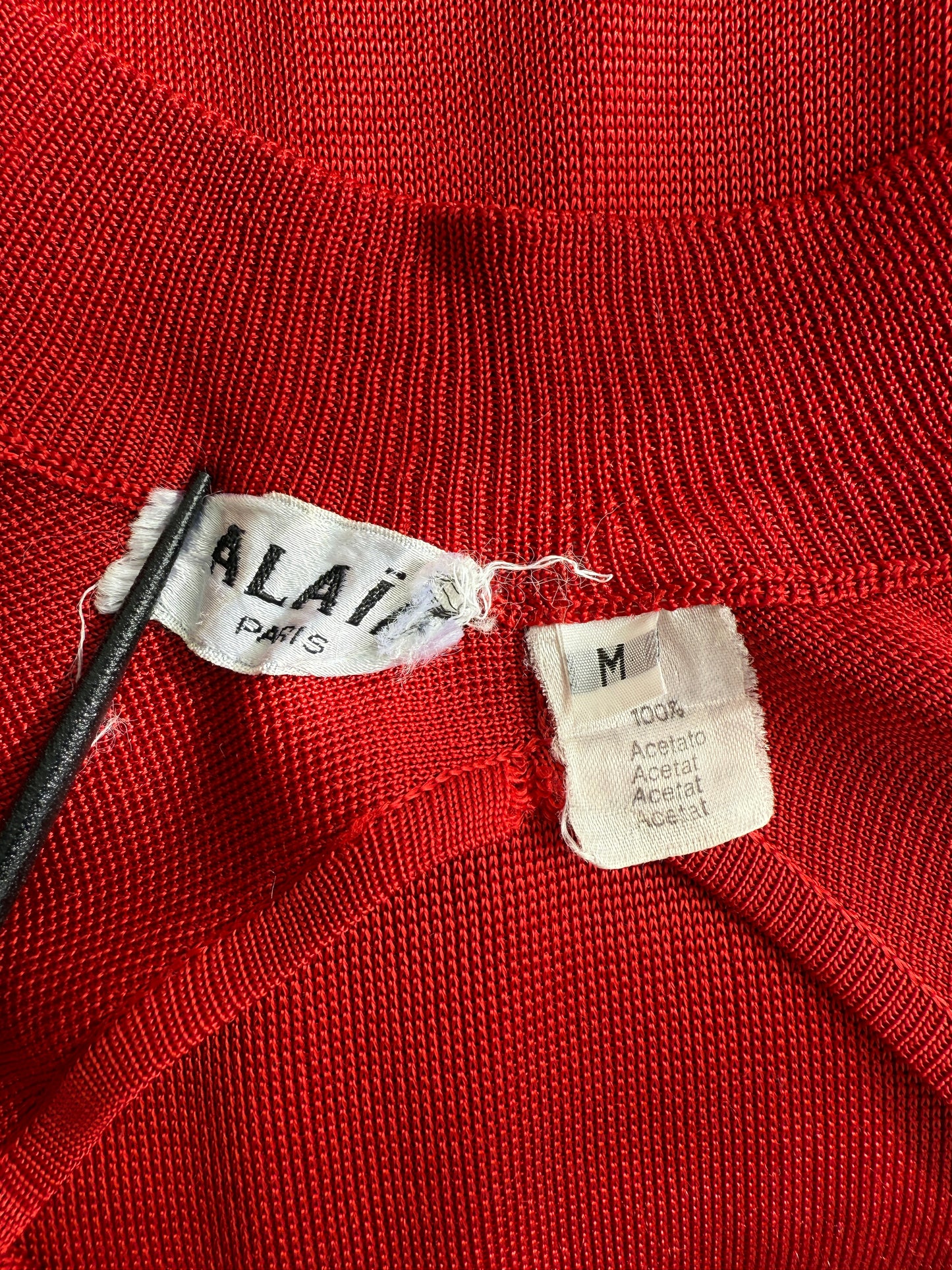 Closeup of the brand label and size tag of the Alaia dress
