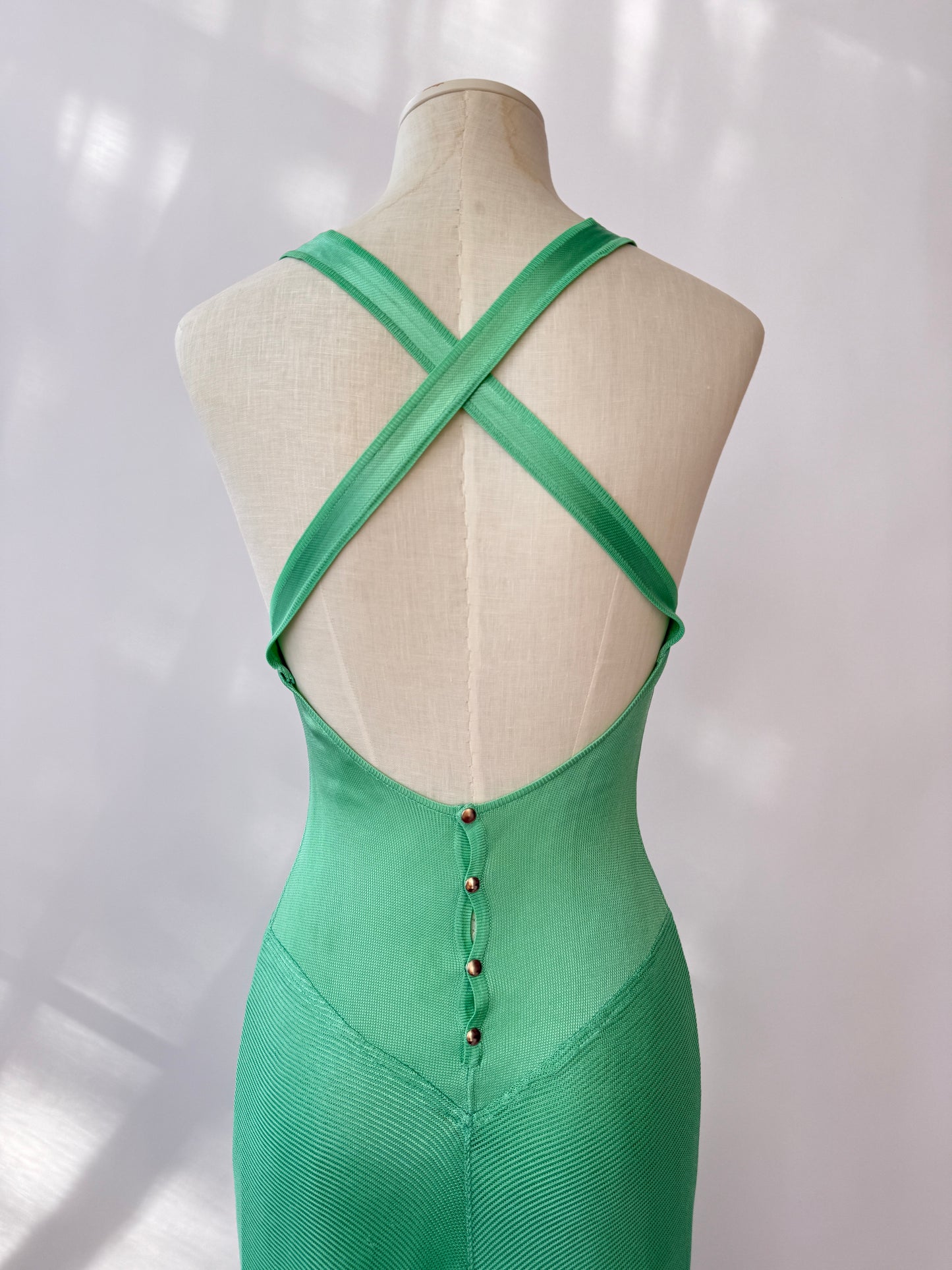 The dress seen from the back in close up on a mannequin buste against a white background.