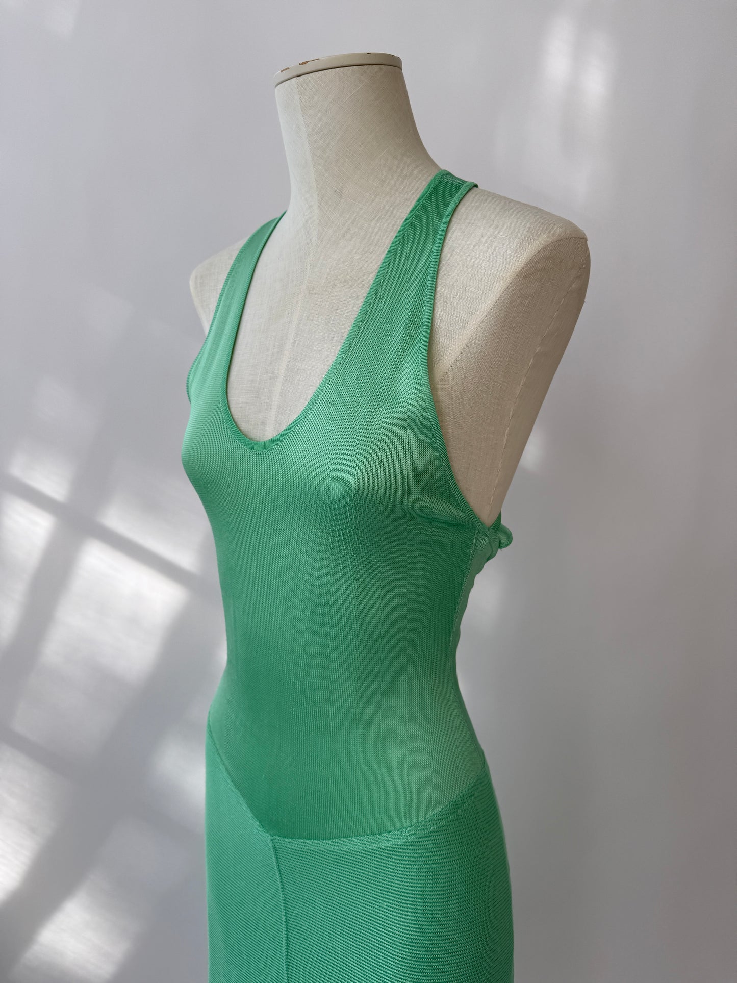 The dress seen from the side in close up on a mannequin buste against a white background.