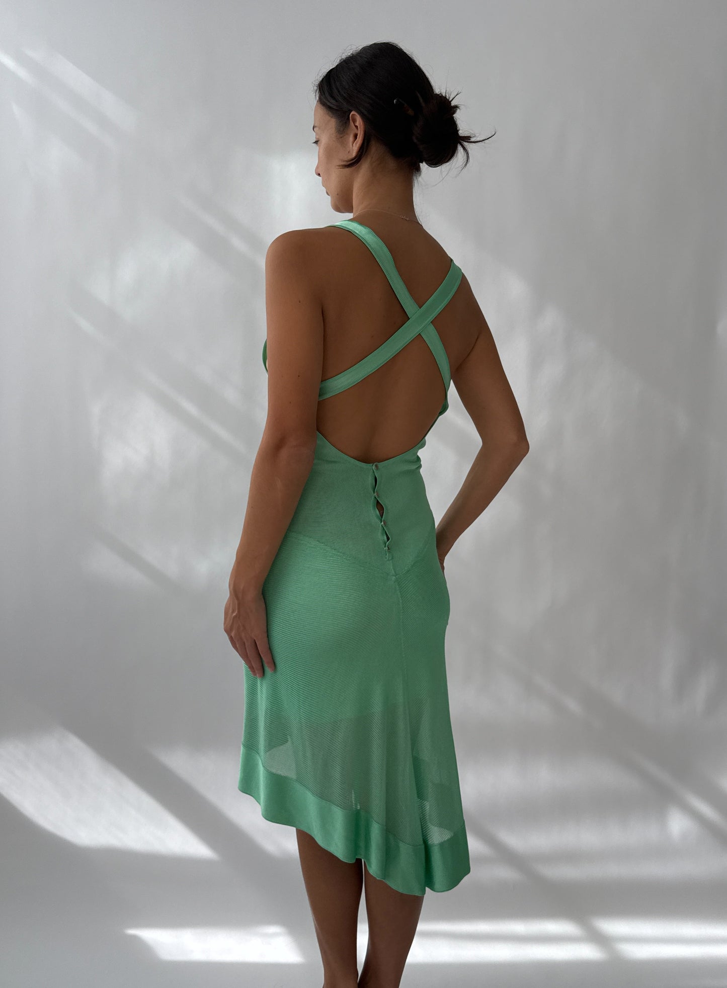 The Alaia S/S 1986 Vintage Asymmetric Open Back Dress worn by a model against a white background seen from the back.