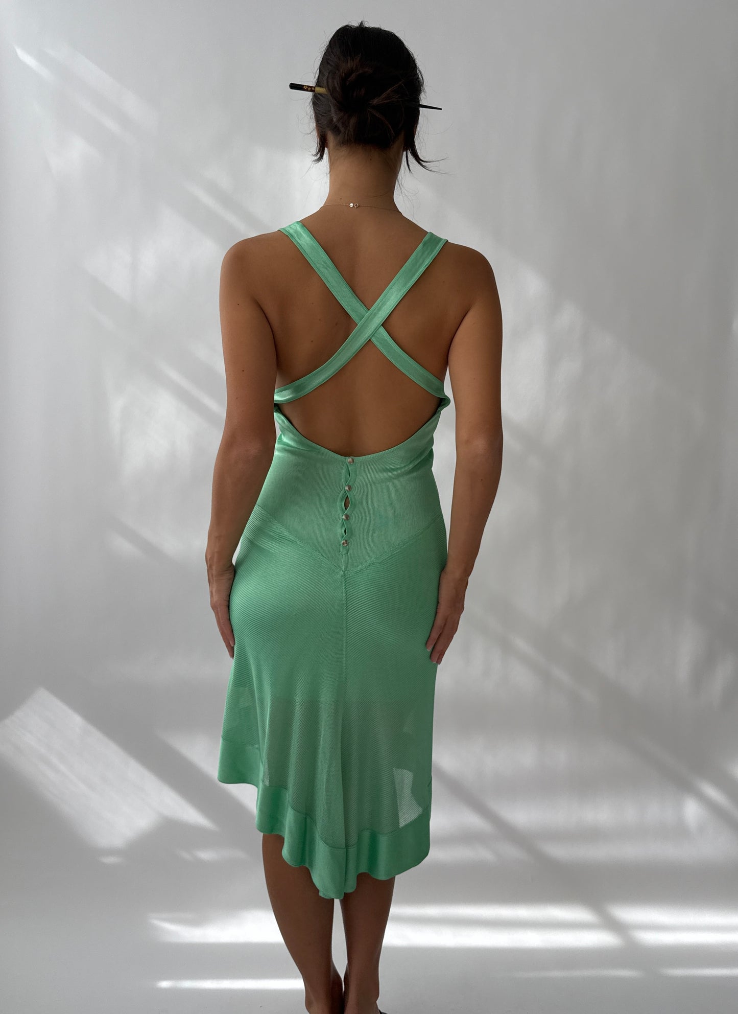 The Azzedine Alaia S/S 1986 Vintage Asymmetric Open Back Dress worn by a model against a white background seen from the back.