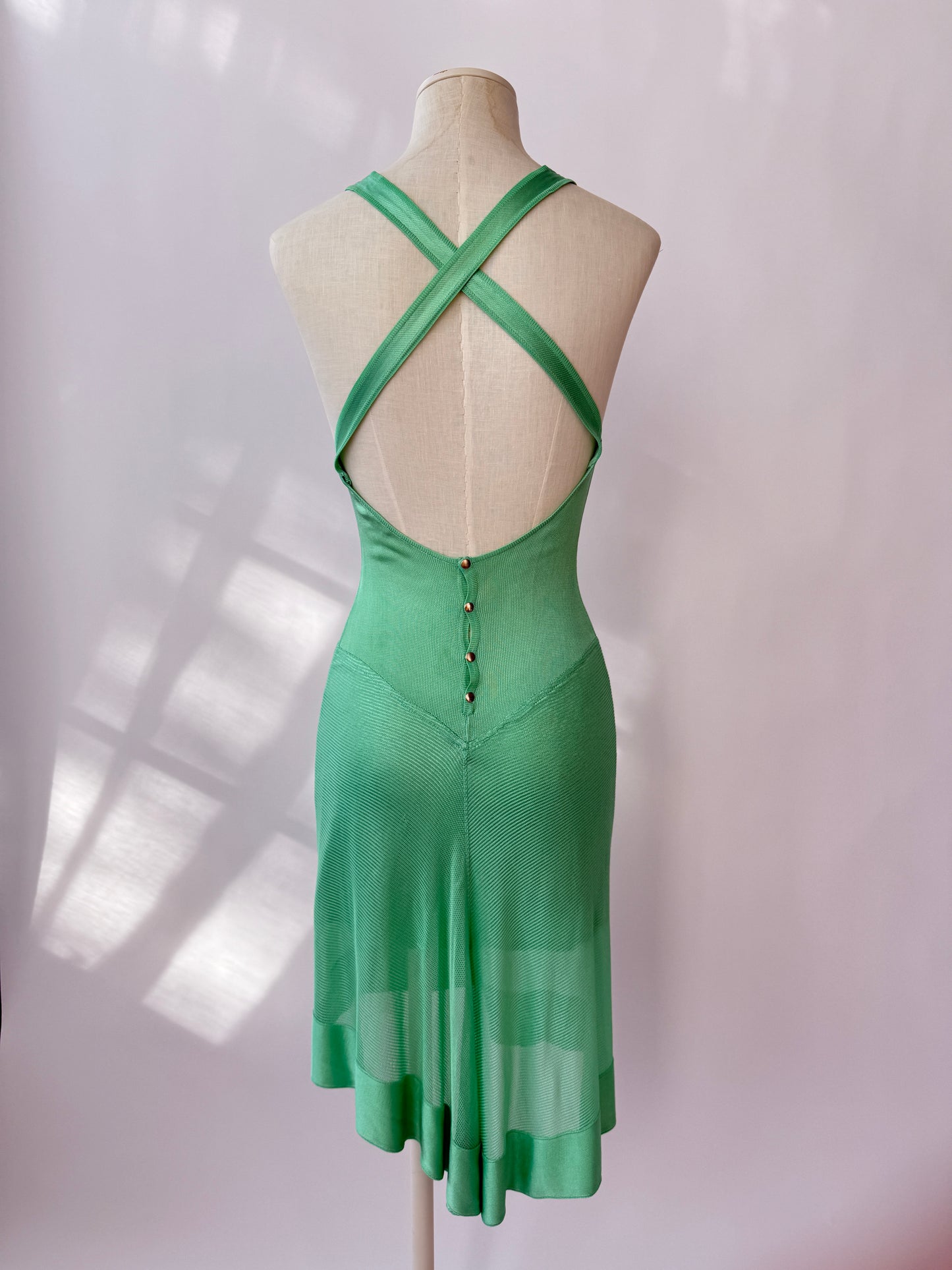 The dress seen from the back on a mannequin buste against a white background.