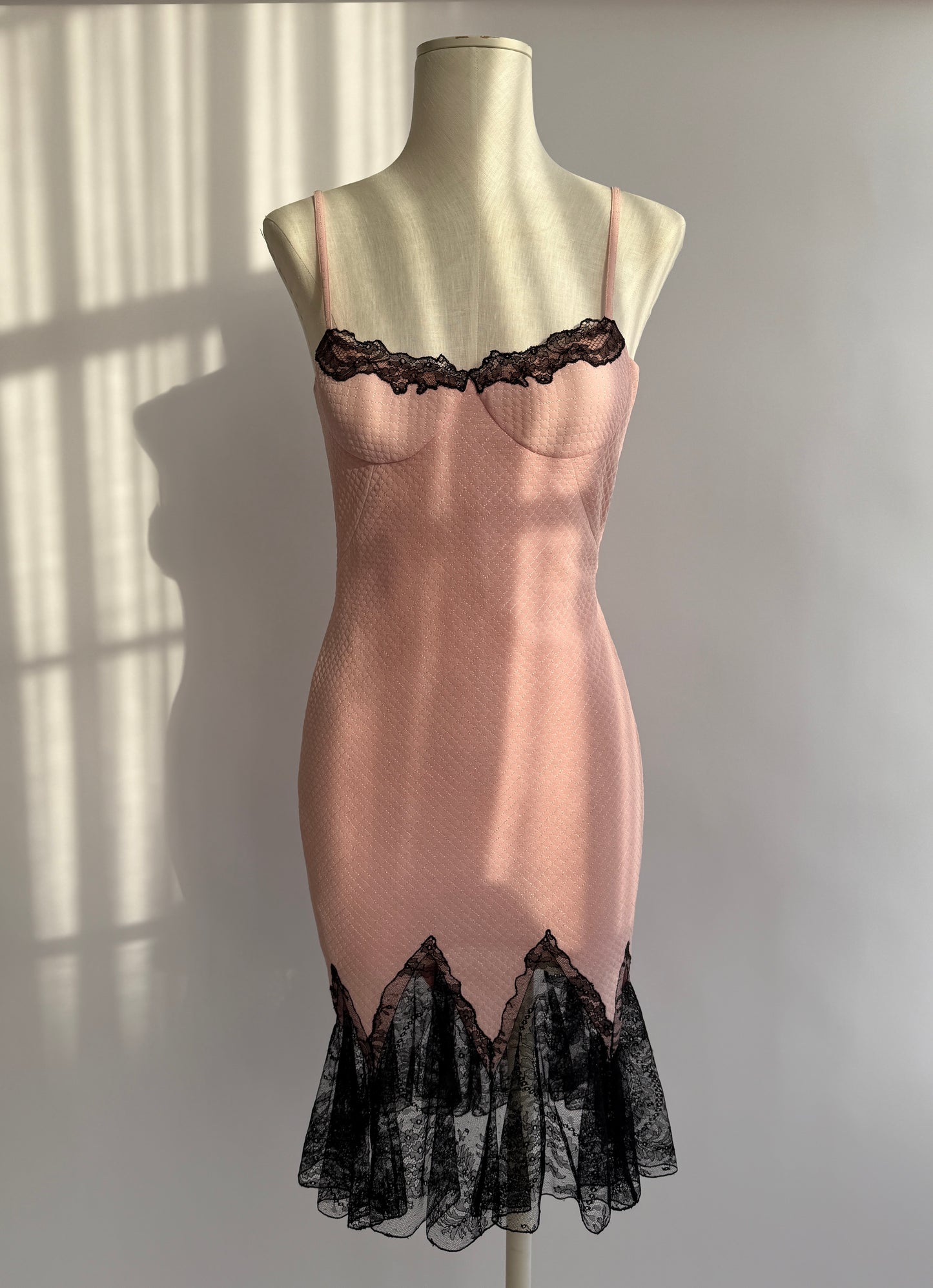 Vintage Versace S/S 2002 dress displayed on mannequin – pink bodycon with lace hem.