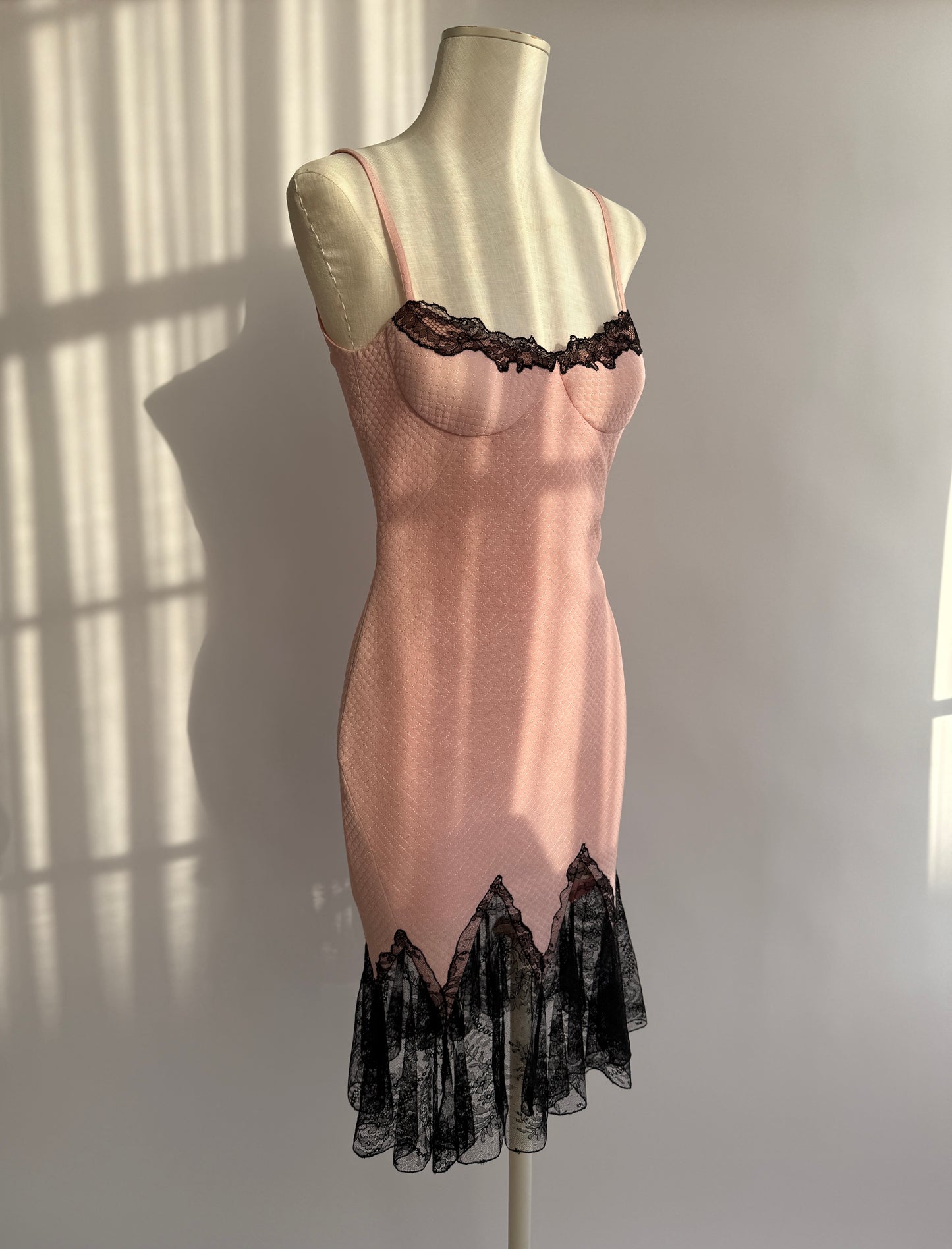 Side view of Vintage Versace S/S 2002 dress displayed on mannequin – pink bodycon with lace hem.