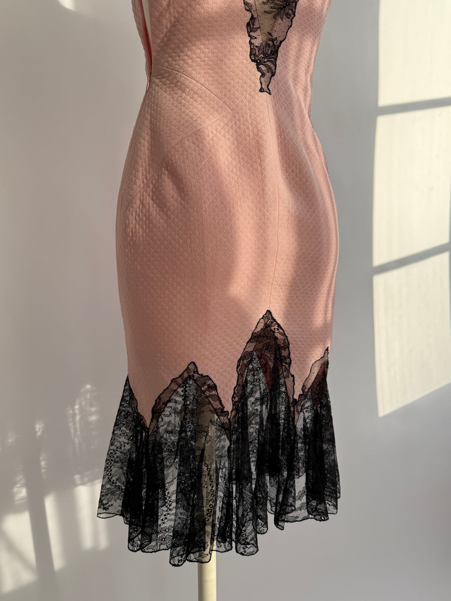 .Close-up of dramatic black lace mermaid hem on Versace S/S 2002 pink dress.