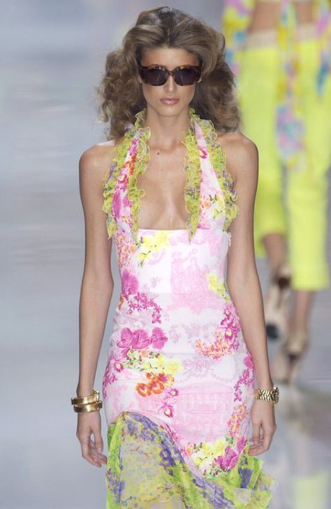 Model walking the Versace Spring/Summer 2004 runway wearing the asymmetric plunging silk ruffled dress in a different color.