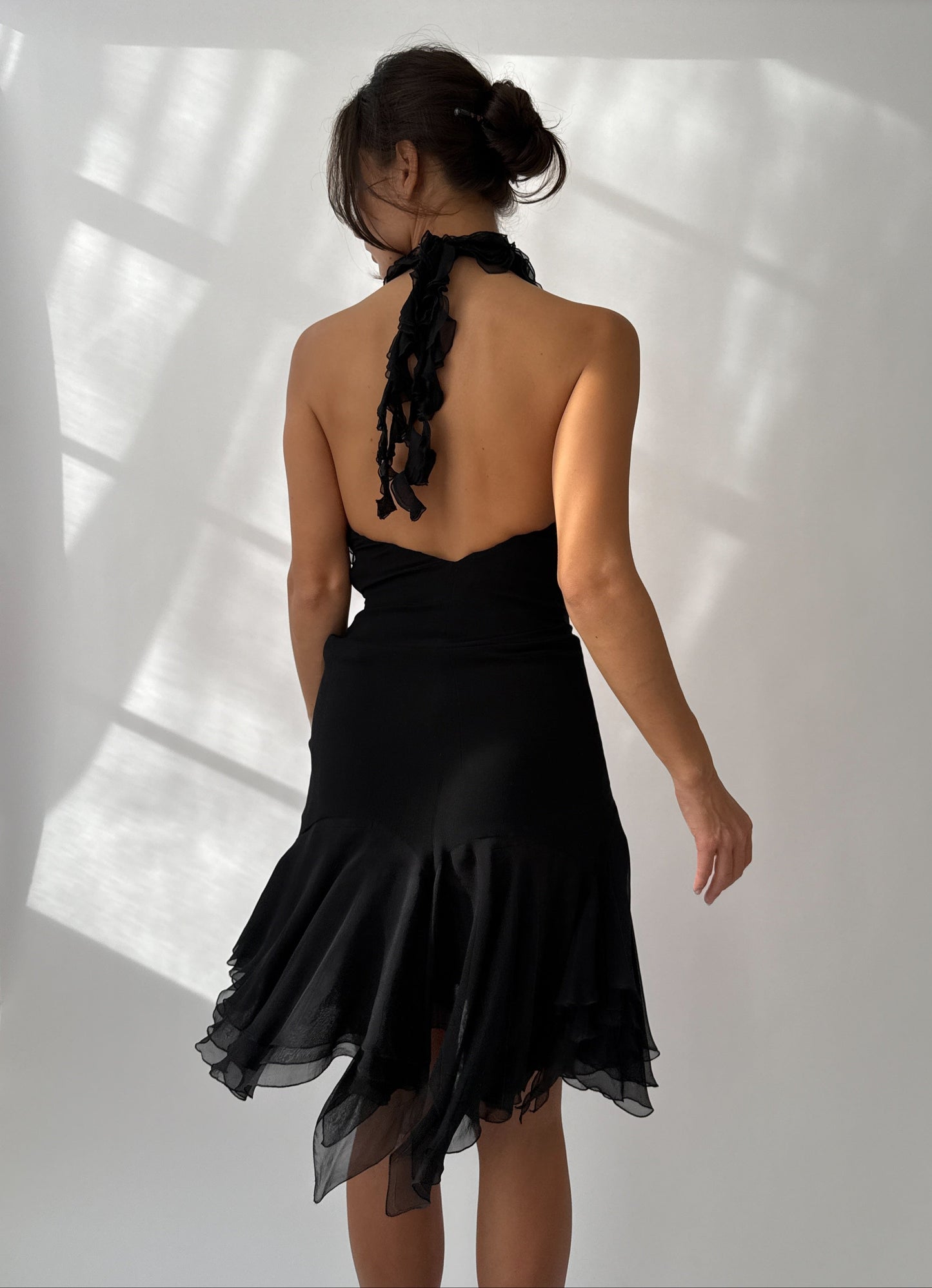 Back view of the vintage Versace ruffled silk dress featuring open design and flowing ruffle detail seen on a model.