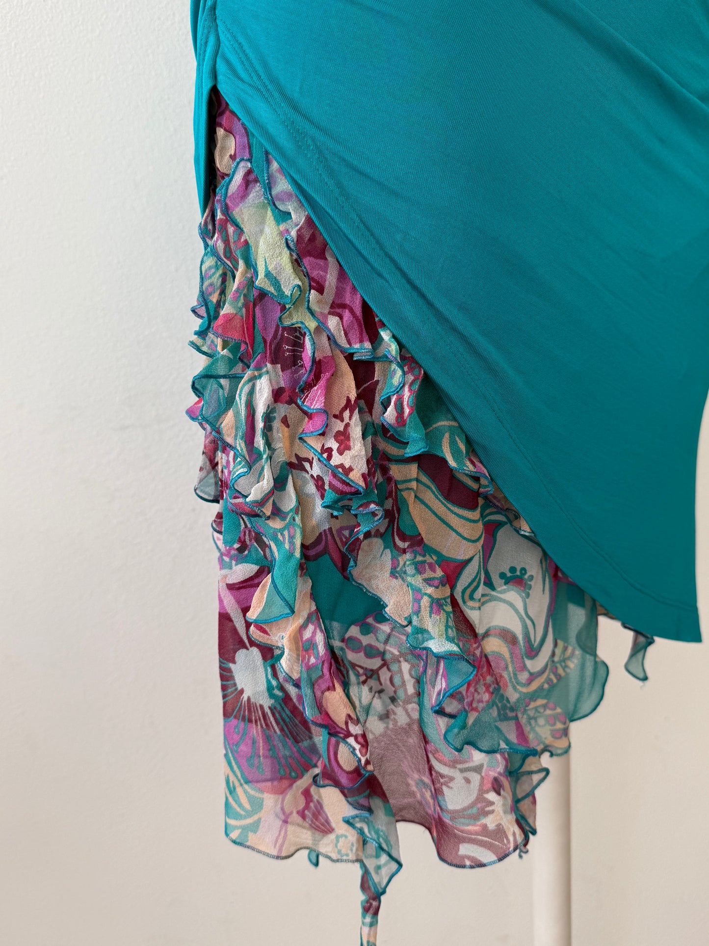 Detailed photo of the silk skirt detail of the Emanuel Ungaro Teal dress on a mannequin