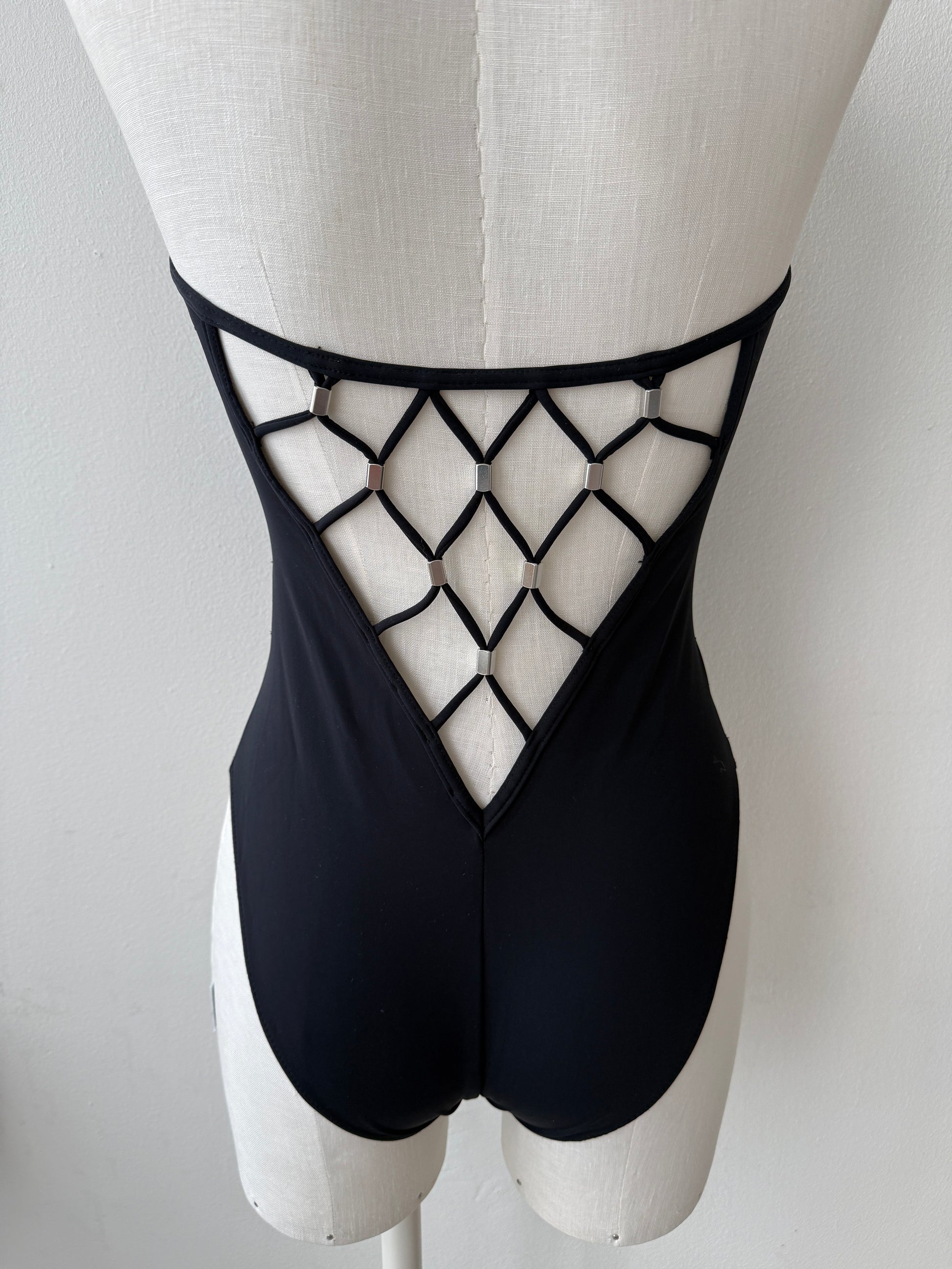 A zoomed-in photo of the open back of the plunging geometrical Paco Rabanne Vintage Swim Suit on a mannequin