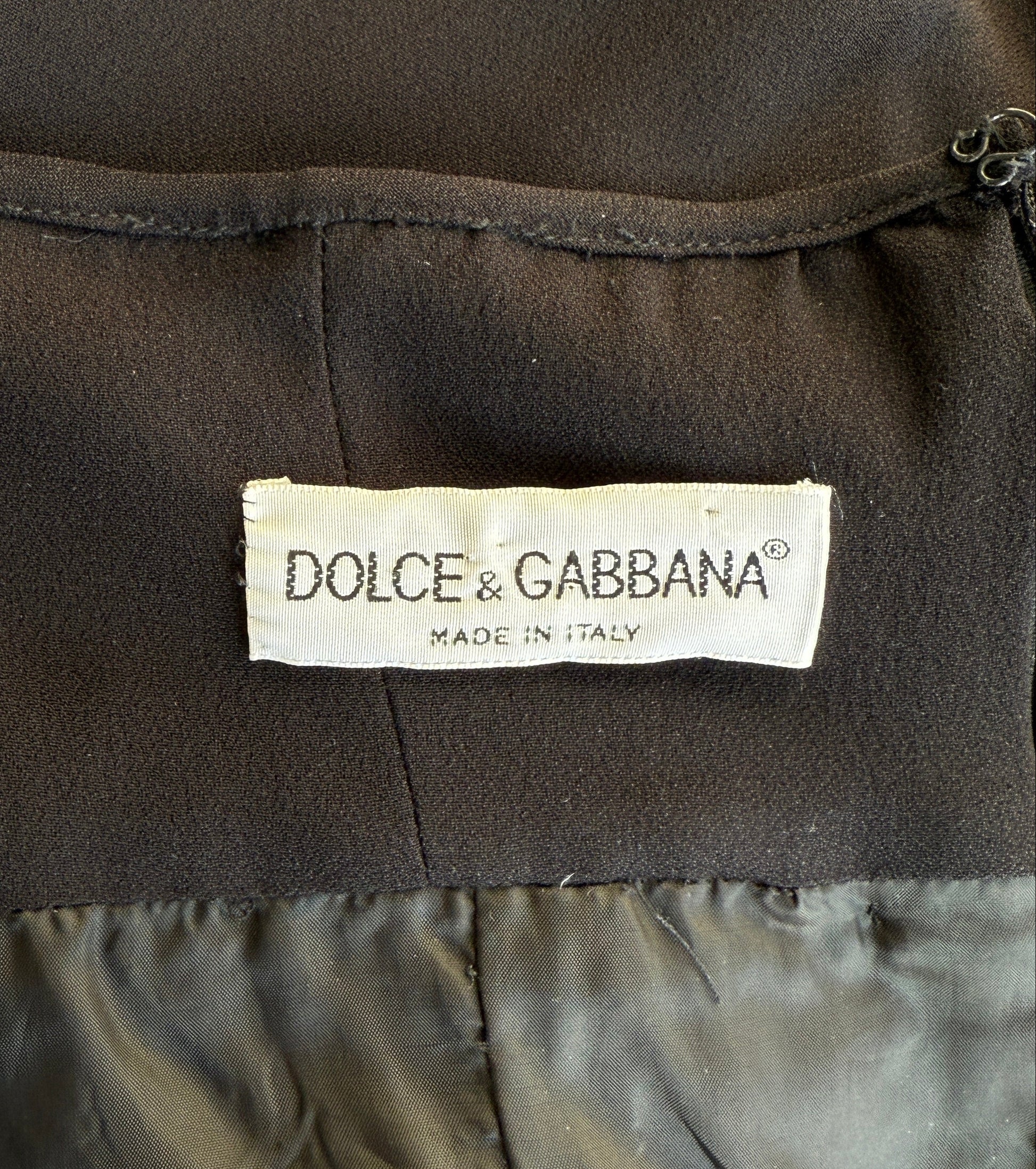 A close-up of the brand label of the Dolce & Gabbana 1995 black halter dress
