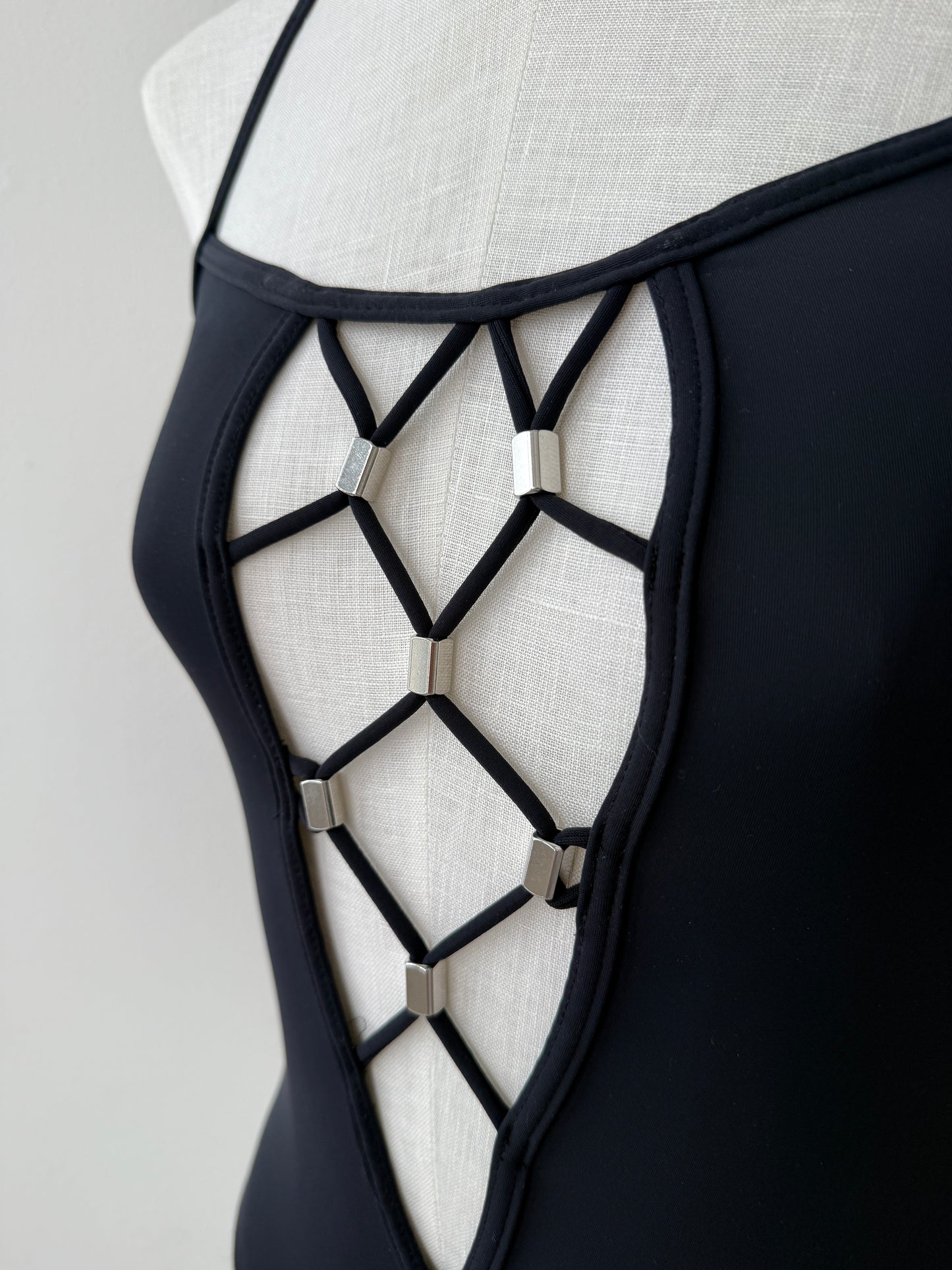 A close-up detail shot of the plunging geometrical neckline with silver embellishments of the Paco Rabanne Vintage Swim Suit 