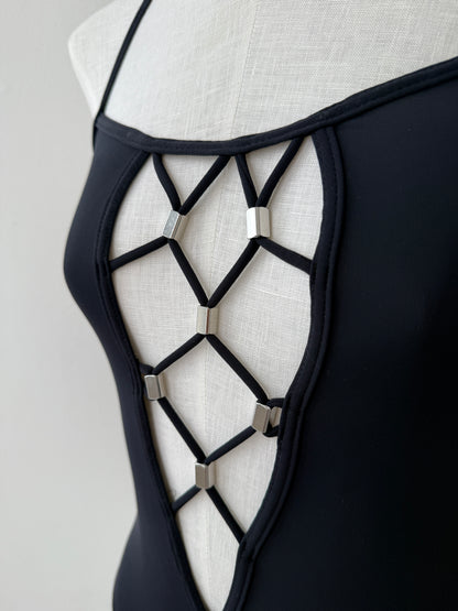 A close-up detail shot of the plunging geometrical neckline with silver embellishments of the Paco Rabanne Vintage Swim Suit 