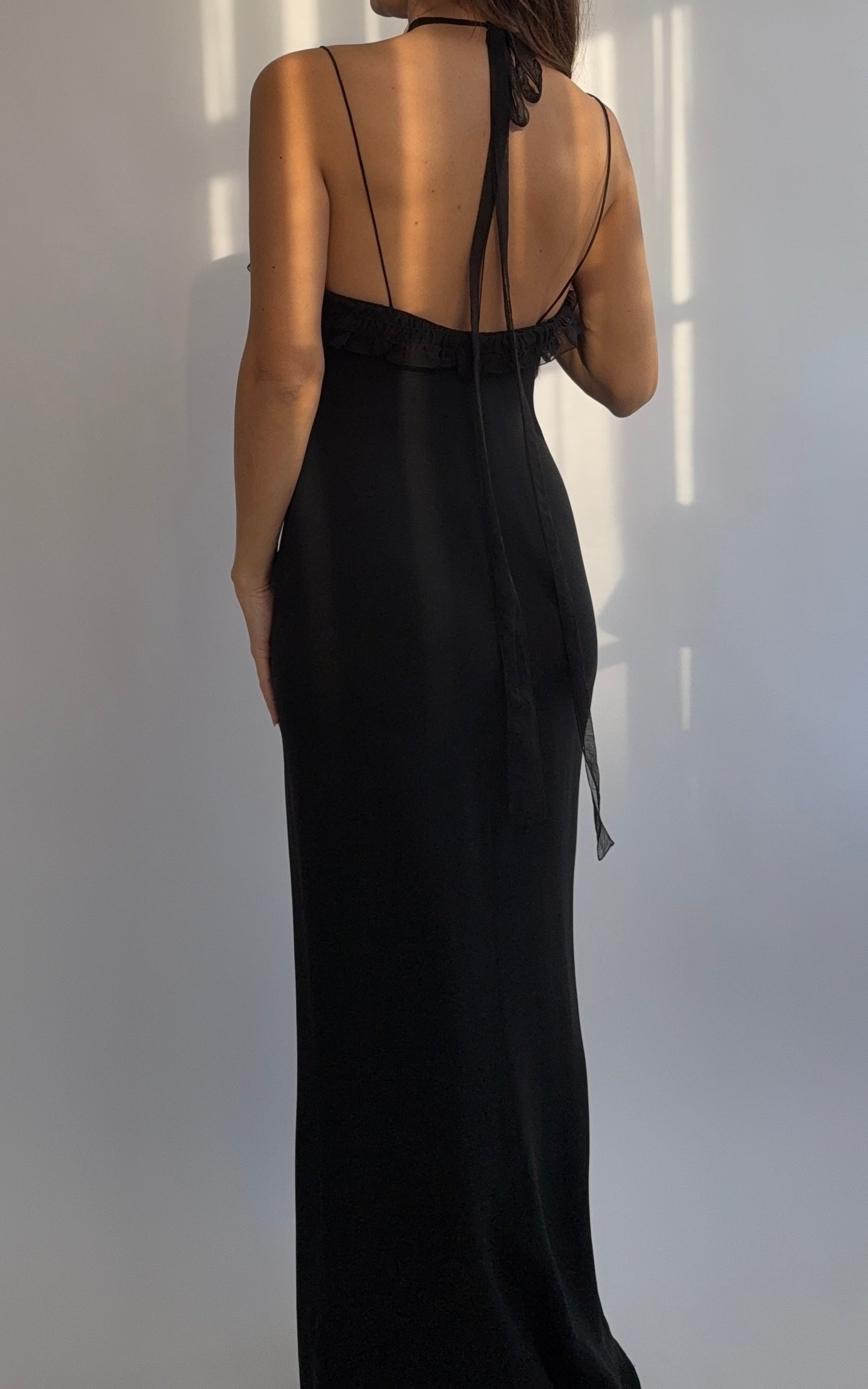 Full length back view of the Emanuel Ungaro 2000's black silk ruched dress on a model.