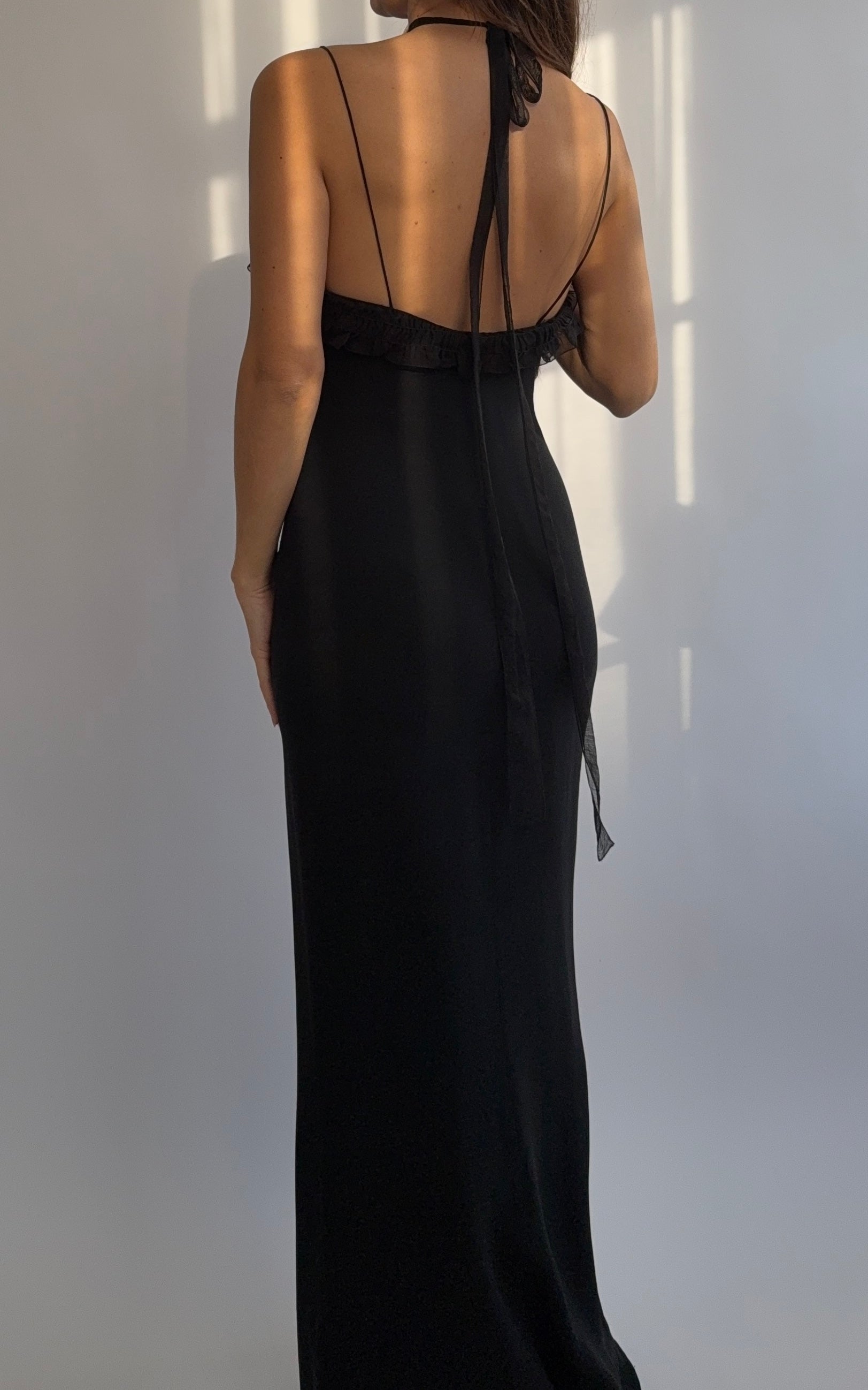 Full length back view of the Emanuel Ungaro 2000's black silk ruched dress on a model.