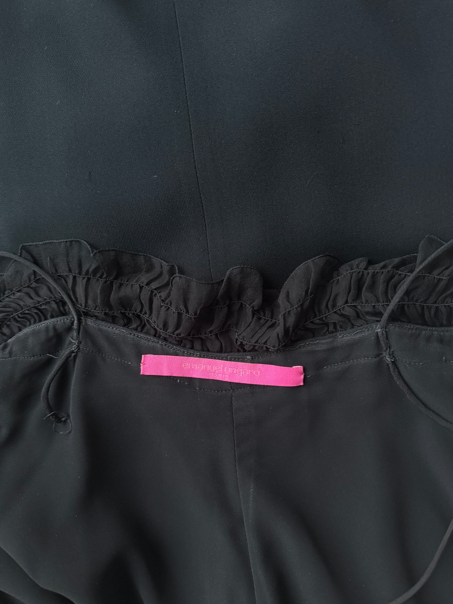 Zoomed in detail photo of the brand label of the Emanuel Ungaro black ruched gown.