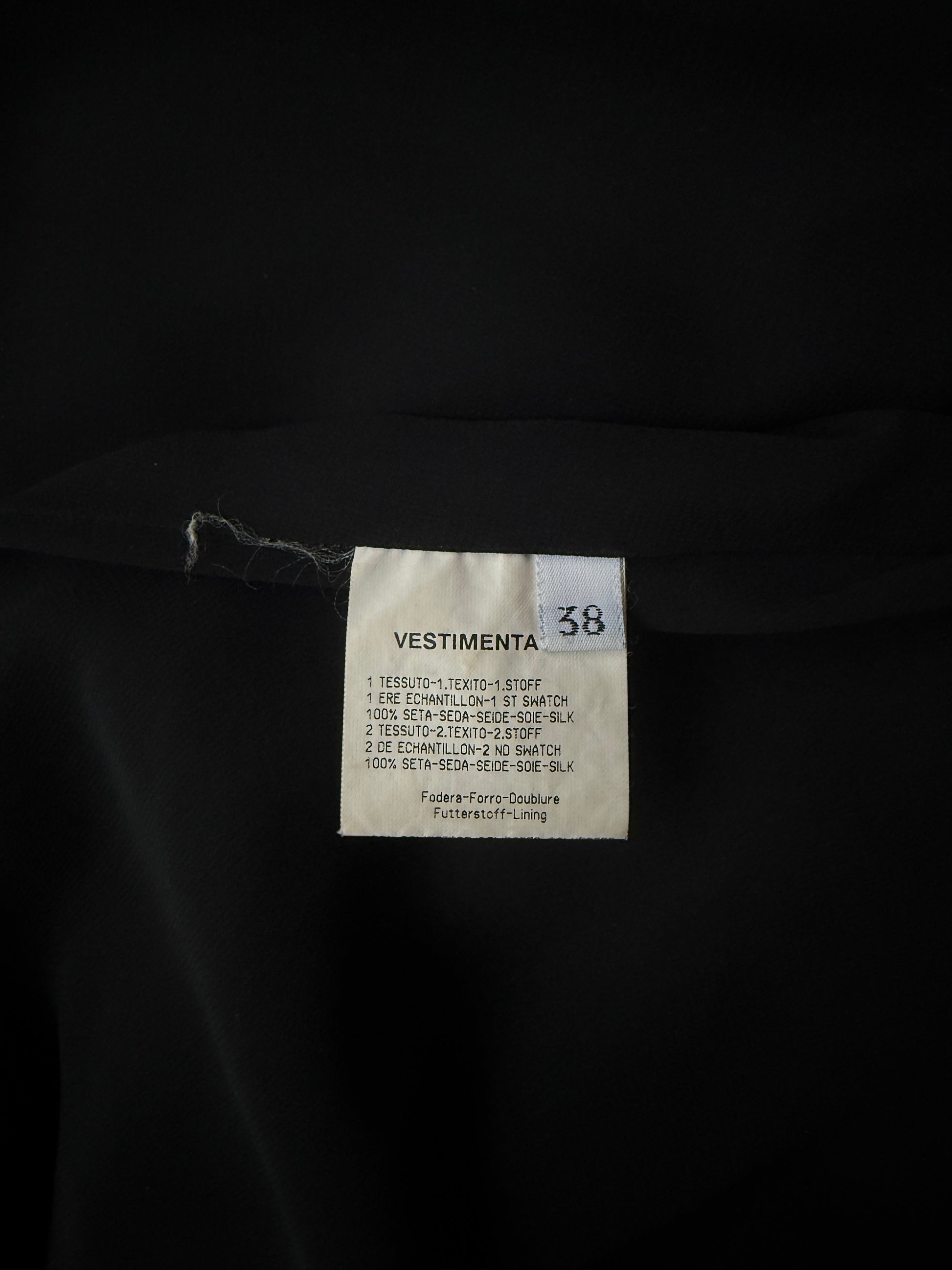 Zoomed in detail photo of the size and care of the Emanuel Ungaro silk halter neck gown.