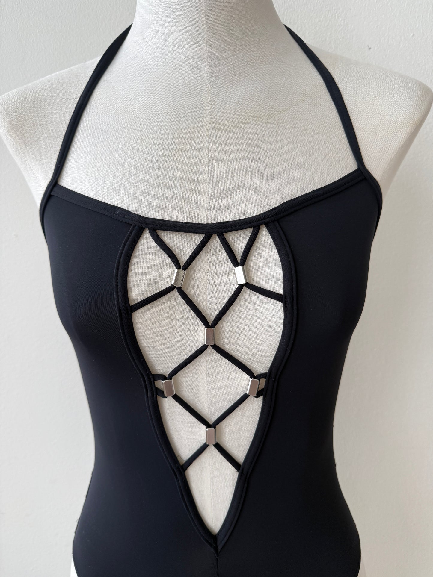 A close-up detail shot of the plunging neckline of the Paco Rabanne Vintage Swim Suit viewed from the front