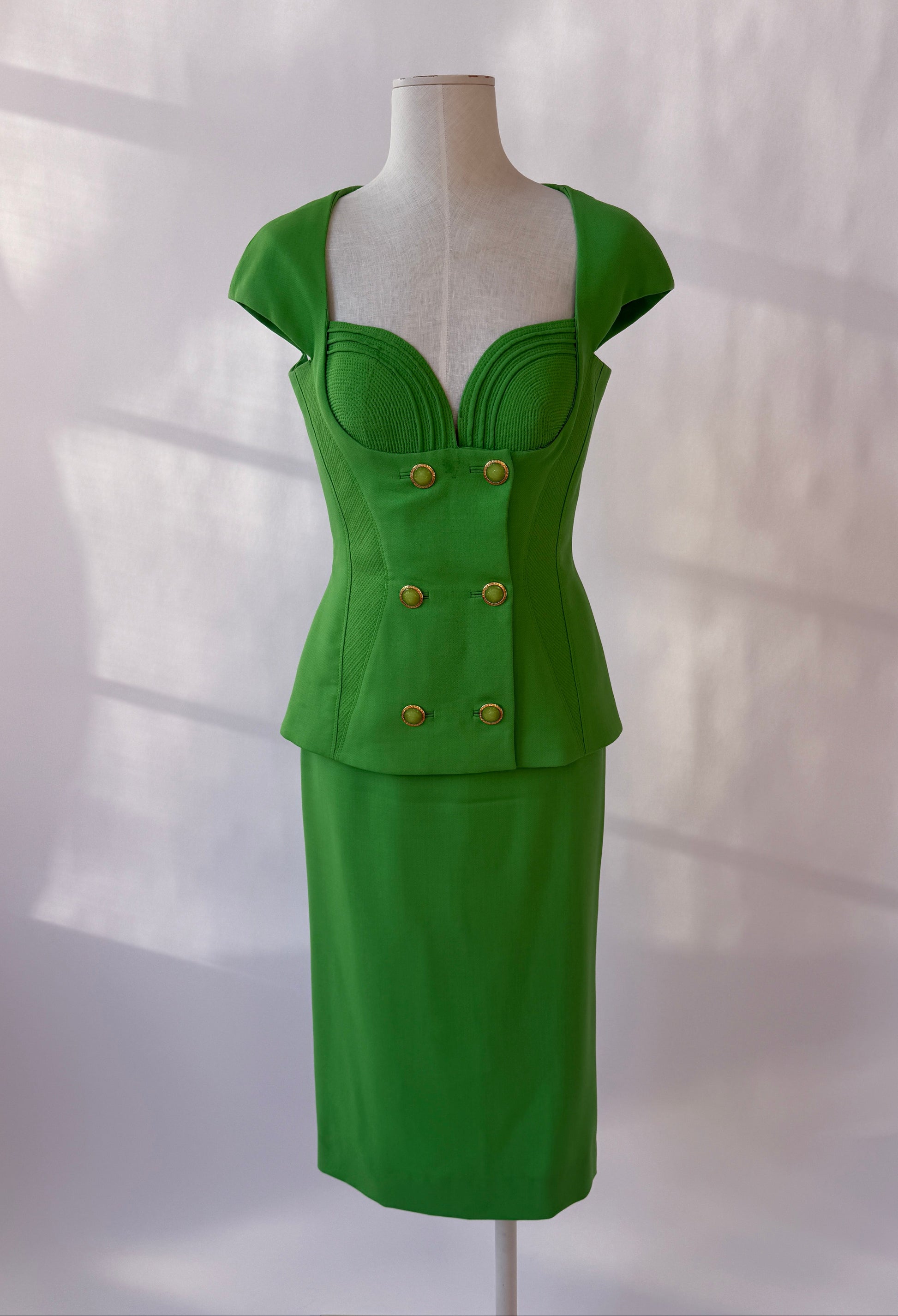 Front view of the green Gianni Versace 1993 Runway Skirt Set on a mannequin.