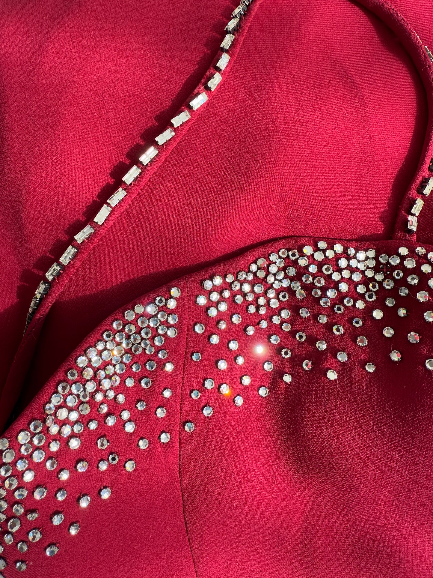 A zoomed-in photo of the shimmering rhinestone embellishments along the neckline of the vintage Versace gown.