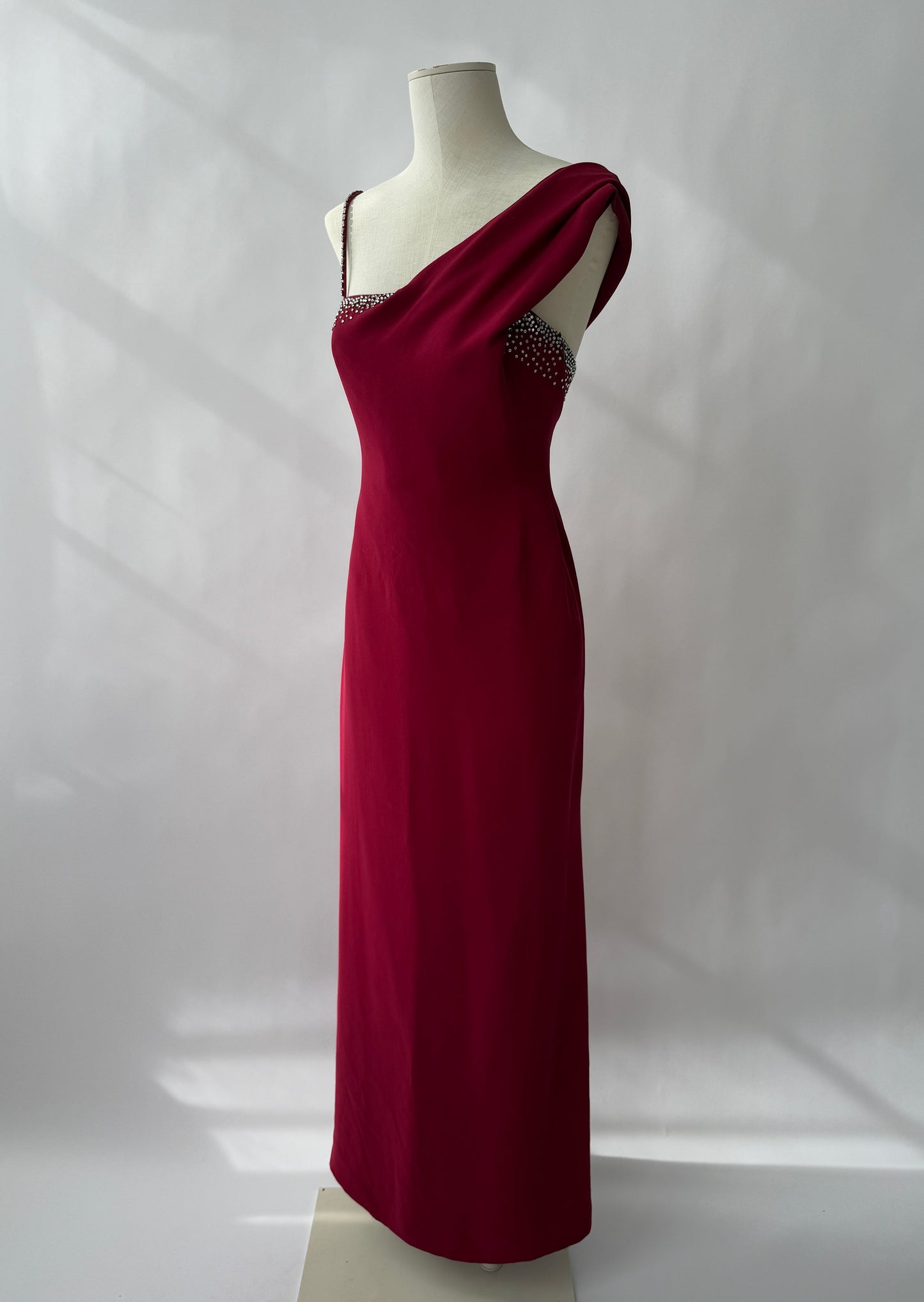 Full length side front view of the Versace 1998 Red Rhinestone Embellished Gown viewed on a mannequin.